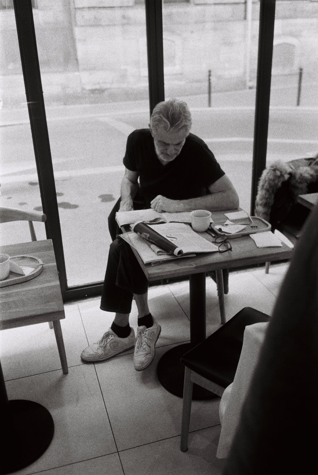 man reading coffee in a magazine in Paris by Lars Gödeke